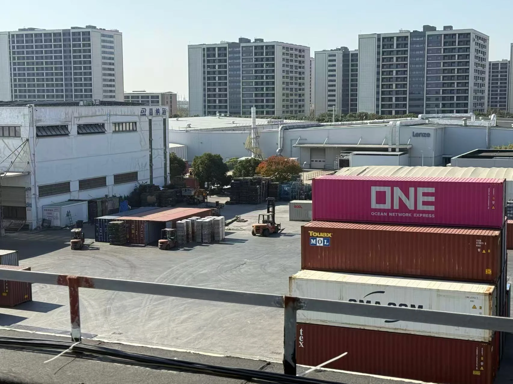 Shipping containers and cargo handling equipment in a container yard.