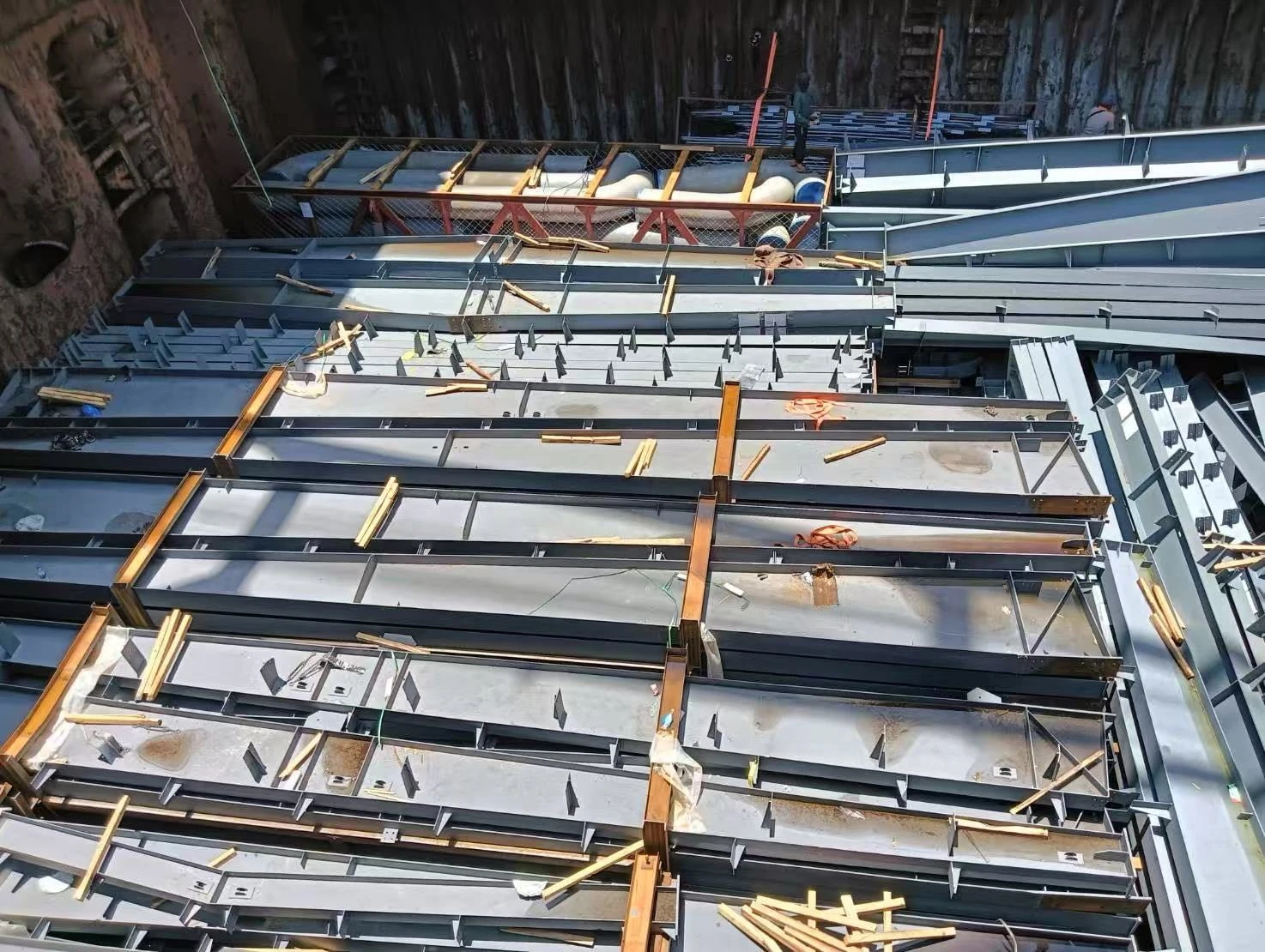 A second view across broad steel sections and raised plates inside the vessel hold.