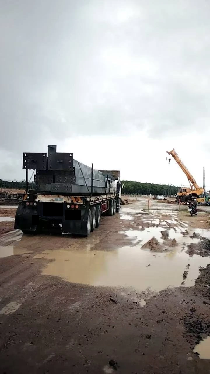 Steel cargo on a truck beside a mobile crane