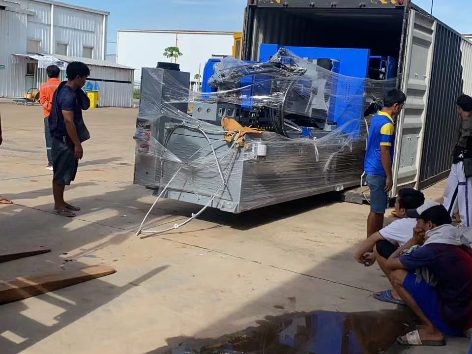 Wrapped machinery being unloaded beside a shipping container